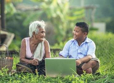 Großmutter und Sohn vor Notebook